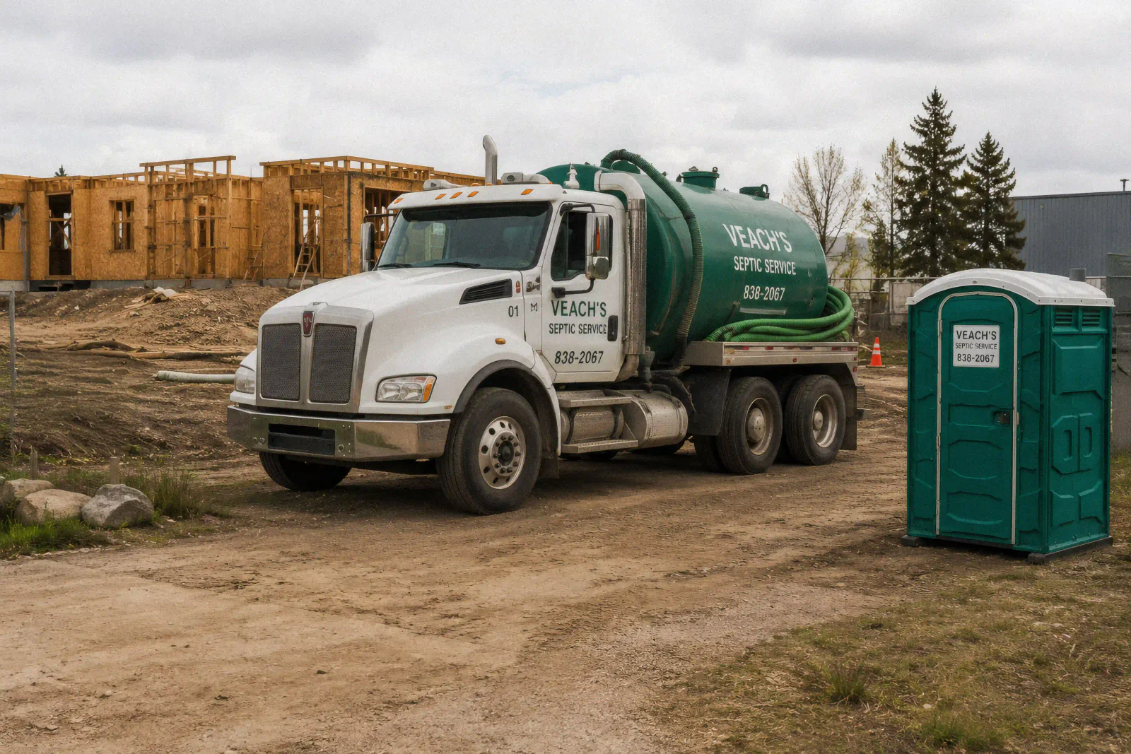Veach's Septic Service vacuum truck and portable toilet at a construction site.